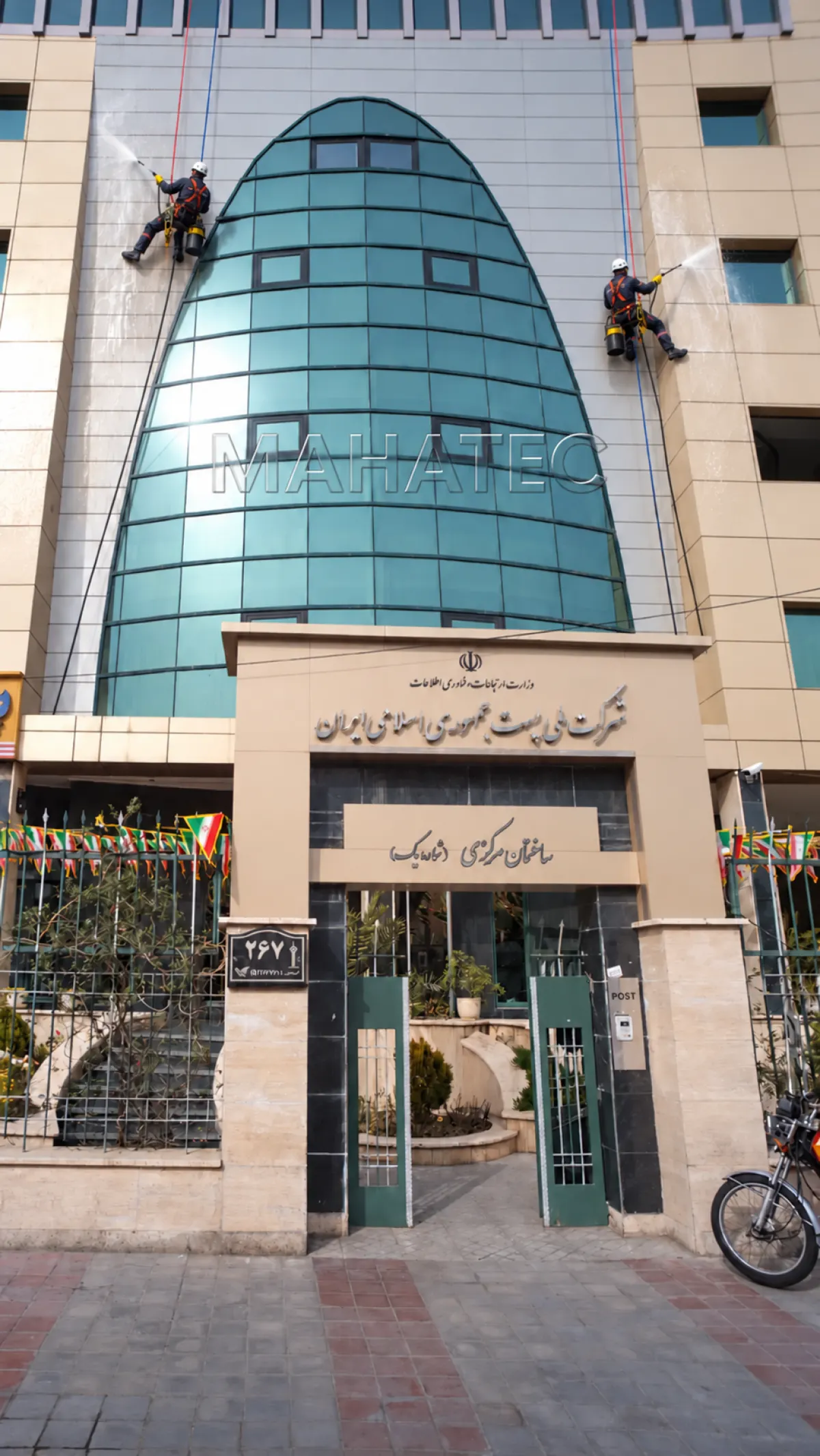 نمای کامپوزیت و شیشهٔ ساختمان شرکت ملی پست با دو راپل‌کار در حال شستشو